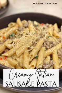 creamy italian sausage pasta with parmesan cheese in a black bowl on a table