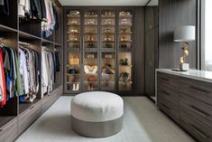 a walk in closet filled with lots of clothes and shoes next to a large window