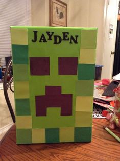 a minecraft creeper made out of paper on top of a wooden table in a room