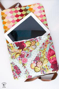 an ipad case is sitting on top of a tablet bag with a strap around it