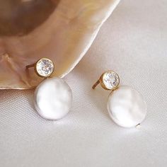 HIGH-LUSTER WHITE FRESHWATER BUTTON PEARL EARRINGS FOR WOMEN - THE AAA QUALITY, GIA-CERTIFIED GENUINE STUD PEARL EARRINGS YOU CAN TRUST! ------------------------------------------------------- Pearls have always been a symbol of natural feminine beauty and power. Conveying unmatched craftsmanship and timeless elegance. These unique freshwater button pearl earrings are the ideal statement piece for your jewelry collection. Offering timeless elegance, and perfect for all occasions. These earrings will become your go-to accessory and are the perfect gift for your loved ones. * Metal: 925 Sterling Silver * Finish: 18k Gold  * Pearl: Natural Freshwater Button Pearl * Gemstone: 5A Grade Round Brilliant Cut Cubic Zirconia, GIA Cutting Standard  * Size: 14-15mm HANDMADE WITH LOVE 🤍 All of our pea Formal White Pearl Crystal Earrings, Delicate White Crystal Earrings For Gift, Dainty White Pearl Drop Bridal Earrings, Elegant White Round Crystal Earrings, White Pearl Crystal Earrings For Pierced Ears, White Pearl Crystal Earrings, White Drop Earrings For Bridesmaid Gift, Delicate White Pearl Earrings For Bridesmaids, White Dainty Crystal Earrings For Wedding