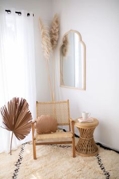 a chair, table and mirror in a room with a rug on the floor next to it