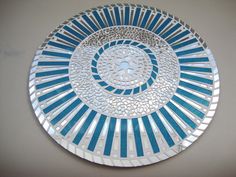 a blue and white plate sitting on top of a table next to a wall mounted clock