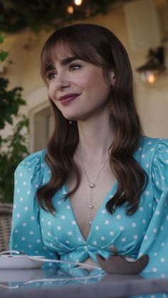 a woman sitting at a table with a fork and spoon in her hand, smiling