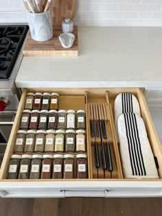 an open drawer with spices and utensils in it