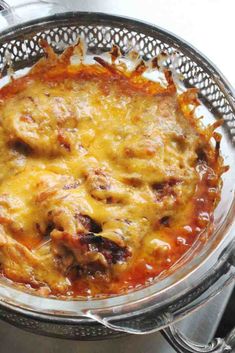 a casserole dish with meat and cheese in a strainer on the stove