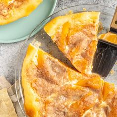 a close up of a pizza pie on a plate with a spatula next to it