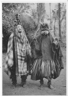 two people dressed in costumes walking through the woods