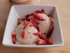 a white bowl filled with ice cream and strawberries