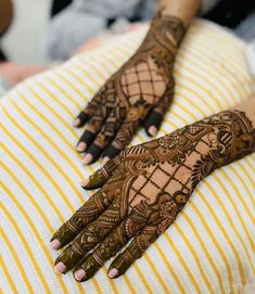 two hands with henna tattoos on them