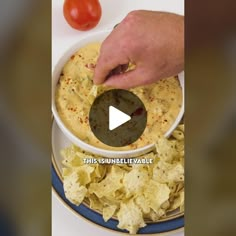 a person is dipping tortilla chips into a white bowl with salsa in it