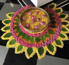 a bowl filled with flowers sitting on top of a black and white checkered floor