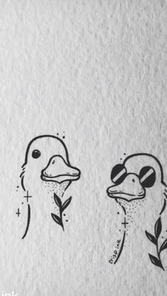 two birds with faces drawn on paper