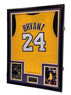 a basketball jersey is hanging in a frame with photos and memorabilia on the wall behind it