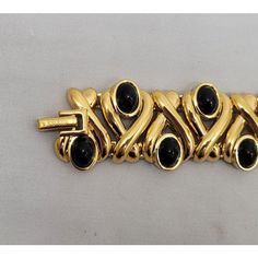 This is part of Chairish’s Costume Jewelry assortment.  980s or 1990s goldtone cabochon faux-onyx articulated link bracelet with fold over clasp. Marked "©Nina Ricci." Measures: 7 3/4 inches long by 7/8 inches. Interior circumference is about 7 inches. Excellent condition, with original tag. Gold Cabochon Bracelets For Formal Occasions, Gold Metal Bracelets With Cabochon, Gold Metal Bracelet With Cabochon, Chanel Bracelet, 18k Gold Bracelet, Garnet Bracelet, Onyx Bracelet, Mesh Bracelet, Gold Bangle Bracelet