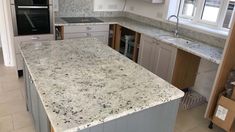 an empty kitchen with granite counter tops and cabinets