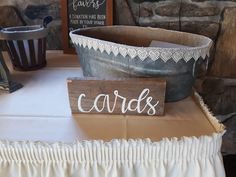 a wooden sign sitting on top of a table next to a bucket and other items