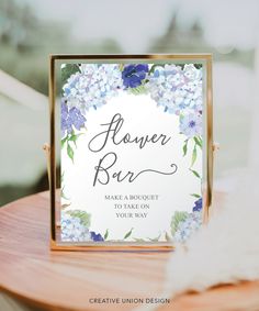 a flower bar sign sitting on top of a wooden table