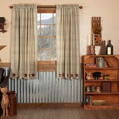 a living room filled with furniture and a large window covered in curtained drapes