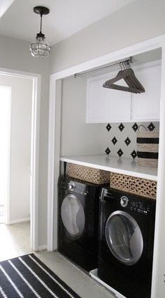 a washer and dryer in a small laundry room with black and white decor