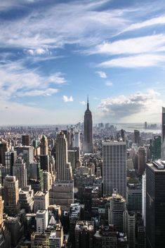 an aerial view of new york city with skyscrapers and blue sky in the background