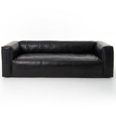 a black leather couch sitting on top of a white floor