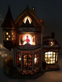 a lit up doll house sitting on top of a table