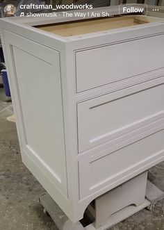 a white cabinet with two drawers on it's sides and the bottom drawer open