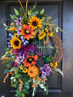 a wreath with sunflowers, pumpkins and other flowers on the front door