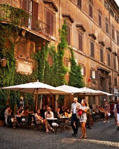 people are sitting at tables in an old european city