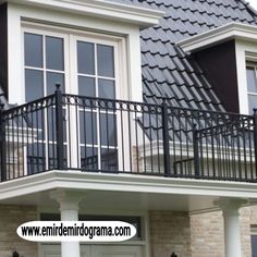 a black iron balcony railing on top of a house