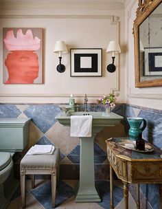 a bathroom with blue and white tiles on the floor, sink, toilet and mirror