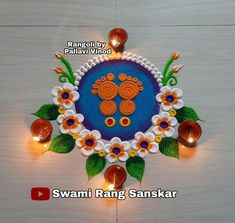 an intricately decorated diya with flowers and candles on the floor for diwaling