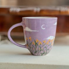 a purple coffee cup sitting on top of a counter