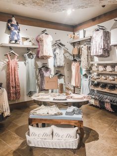 the inside of a clothing store with clothes on display