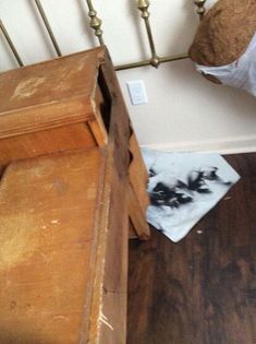 a teddy bear sitting on top of a wooden chair next to a bed with white sheets