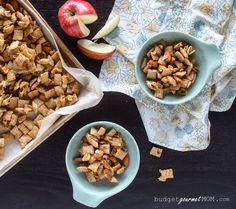 two bowls filled with cereal next to an apple