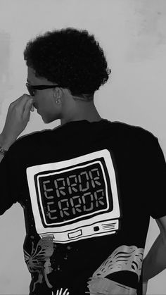 a black and white photo of a person wearing a t - shirt with an electronic message on it