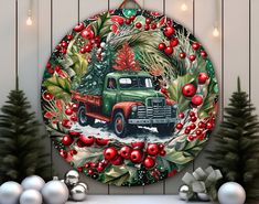 a green truck decorated with red ornaments and greenery sits in front of christmas trees