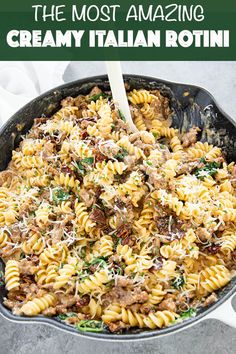 a skillet filled with pasta, meat and parmesan cheese being stirred by a wooden spoon