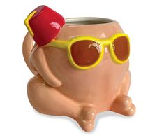 a ceramic cup with sunglasses and a cap on it's head, sitting in the shape of an elephant