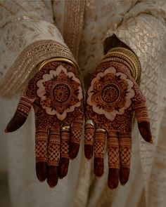 two hands with henna designs on them