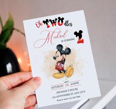 a person holding up a mickey mouse birthday card