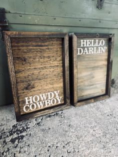 two wooden signs that say hello, darlin and howdy cowboy on the side of a building