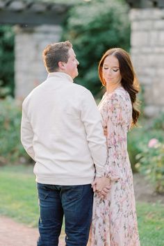 an engaged couple holding hands and looking at each other