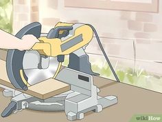 a person is using a circular saw to cut wood with a power tool on the table