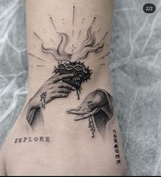 a tattoo on the foot of a person with two hands holding an object in front of them