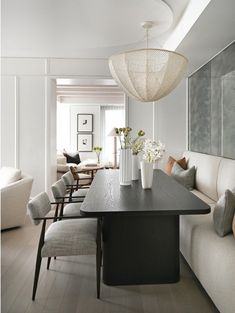 a dining room table with chairs and vases on it