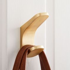 a pair of brown leather straps hanging on a white door