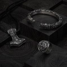 an assortment of rings and bracelets sitting on top of a wooden block in the dark